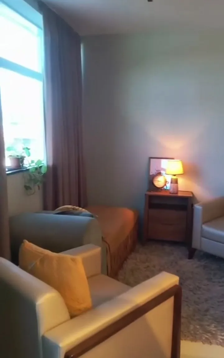 Sala de atendimento do consultório de Julia Stefe, com poltronas claras, tapete e luz natural